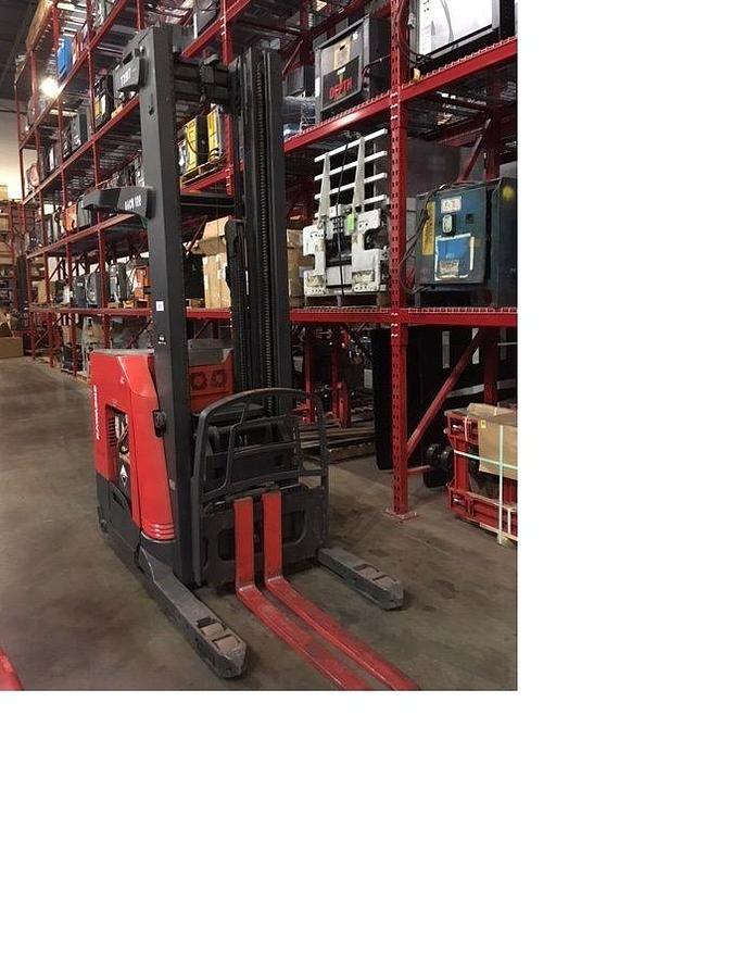 Rear-angle reverse view of Raymond 750DR32TT deep-reach forklift cradled on flatbed trailer for shipment, showing counterweight, rear wheels, and mast secured with transport straps during Brampton deployment