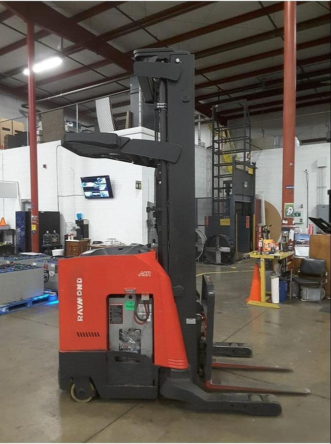 Side view of refurbished 2013 Raymond 750R45TT electric reach truck showing battery compartment, chassis frame, and single reach carriage during Vaughan deployment