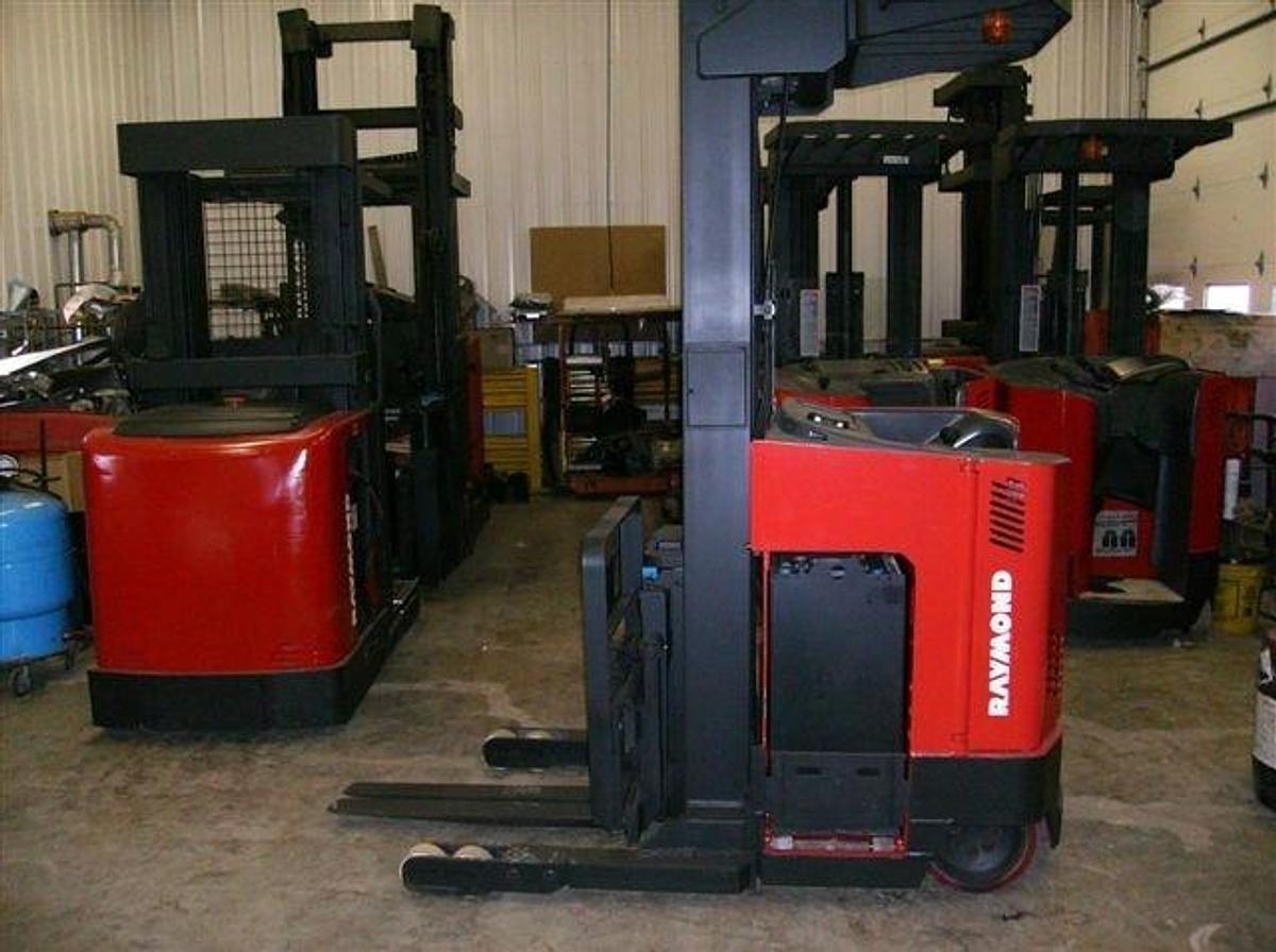 Side view of refurbished 2002 Raymond EASIR40TT electric reach truck showing battery compartment, chassis frame, and 33" base legs during Brampton deployment