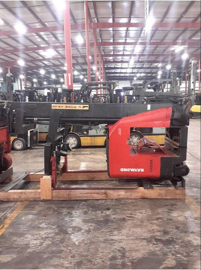 Side view of refurbished 2010 Raymond 740R45TT electric reach truck laid down and cradled for shipment, showing chassis frame, mast rails, and reach mechanism secured for transport during Concord deployment