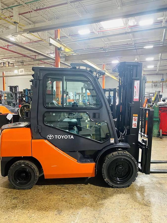 Side view of CSA-certified Toyota 8FGU30 propane forklift with triple mast and full cab – staged in Brampton ON