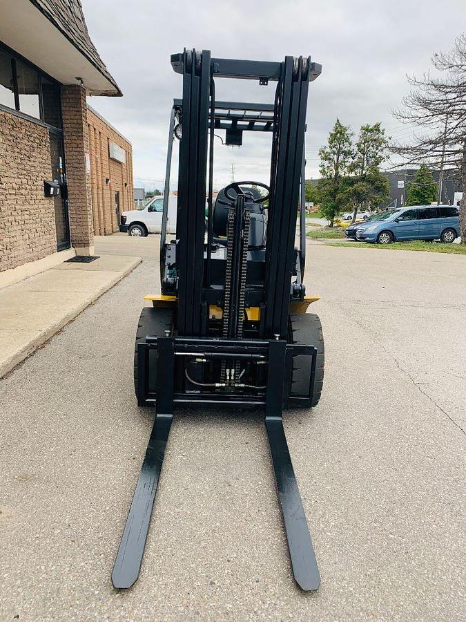Front view of Komatsu FG25T‑14 forklift showing forks, three‑stage mast, and CSA certification decal during Brampton deployment