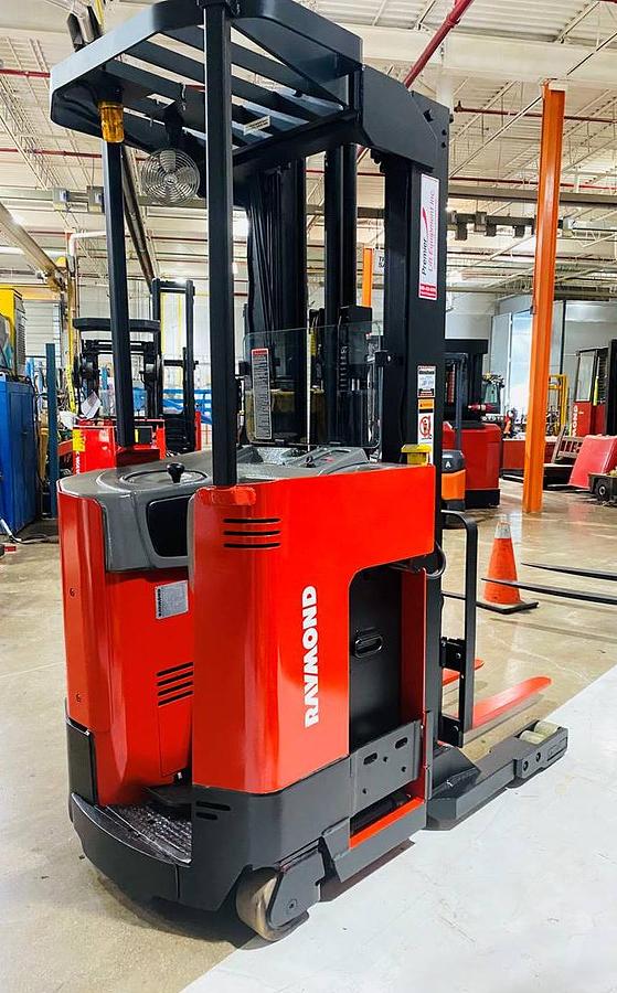 Rear side angle view of Raymond EASIR40TT electric reach truck shown chassis only without battery or charger – CSA-certified 4,000 lb unit featuring 211” triple mast, 36V electric powertrain, rear counterweight, and narrow-aisle polyurethane tires staged in Brampton ON; battery and charger available separately as extra options new or used – Premier Lift Equipment