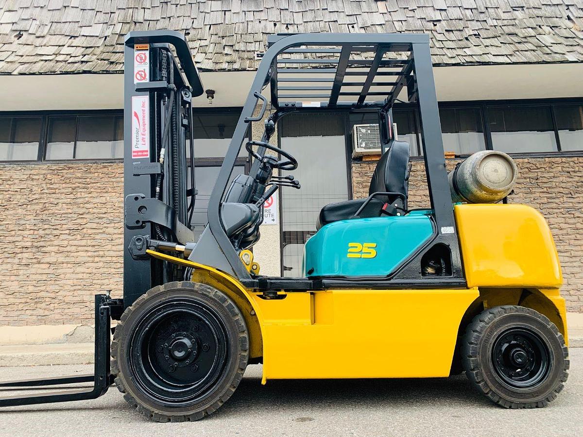 Side view of refurbished 2008 Komatsu FG25T‑14 pneumatic tire forklift showing forks, mast, and CSA certification decal during Brampton deployment