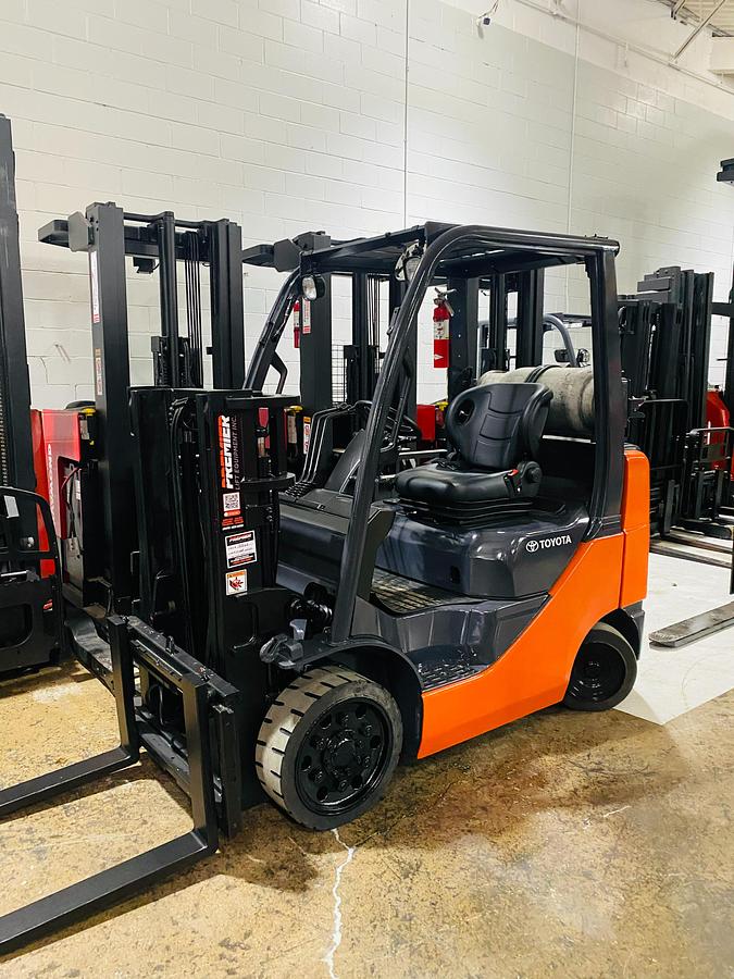 Side view close-up of 2011 Toyota 8FGCU20 propane forklift – CSA-certified 4,000 lb chassis showing operator station, overhead guard, and propane tank bracket with traction cushion tires and safety decals applied, Brampton ON – Premier Lift Equipment