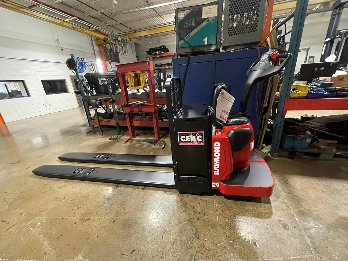 Side view of refurbished 2014 Raymond 8410 electric rider pallet truck showing battery compartment, fixed platform, and 97" forks during Toronto deployment