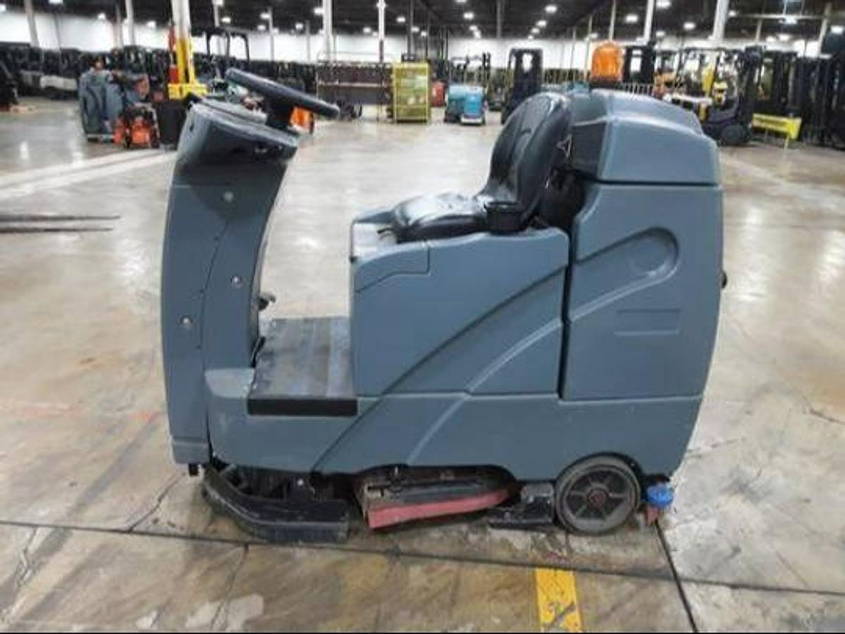 Side view of refurbished 2019 Factory Cat RS25 electric rider sweeper‑scrubber showing 26" wide cleaning path, 24 volt chassis, and CSA certification decal during Brampton deployment.