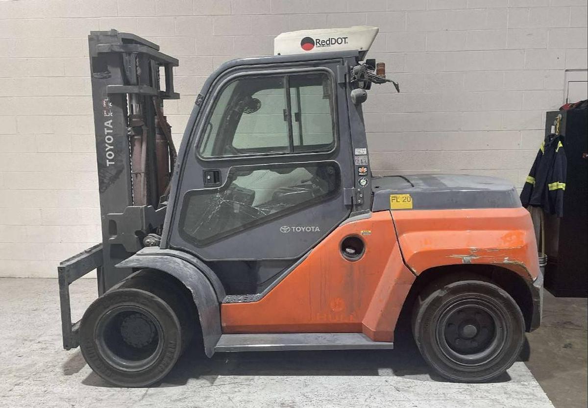 Opposite side view of refurbished 2019 Toyota 8FD70U diesel forklift showing full cab enclosure, rear chassis, and CSA decal during Brampton deployment