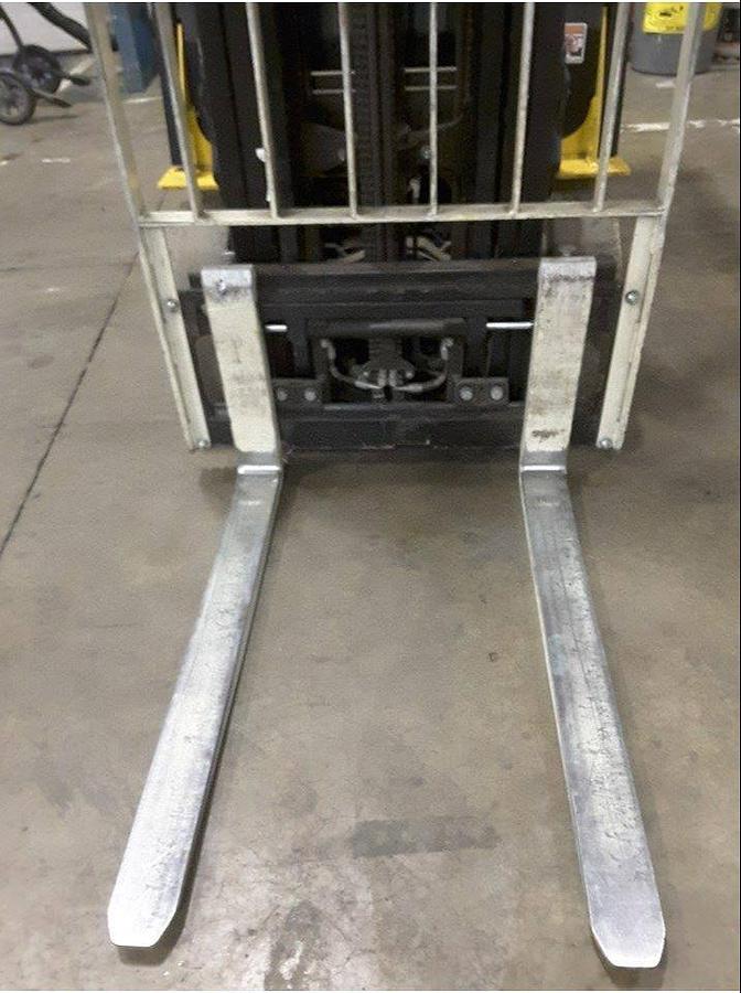 Close-up view of forks, carriage, and side shift mechanism on refurbished electric forklift showing taper profile, hydraulic block, and CSA decal during Brampton deployment