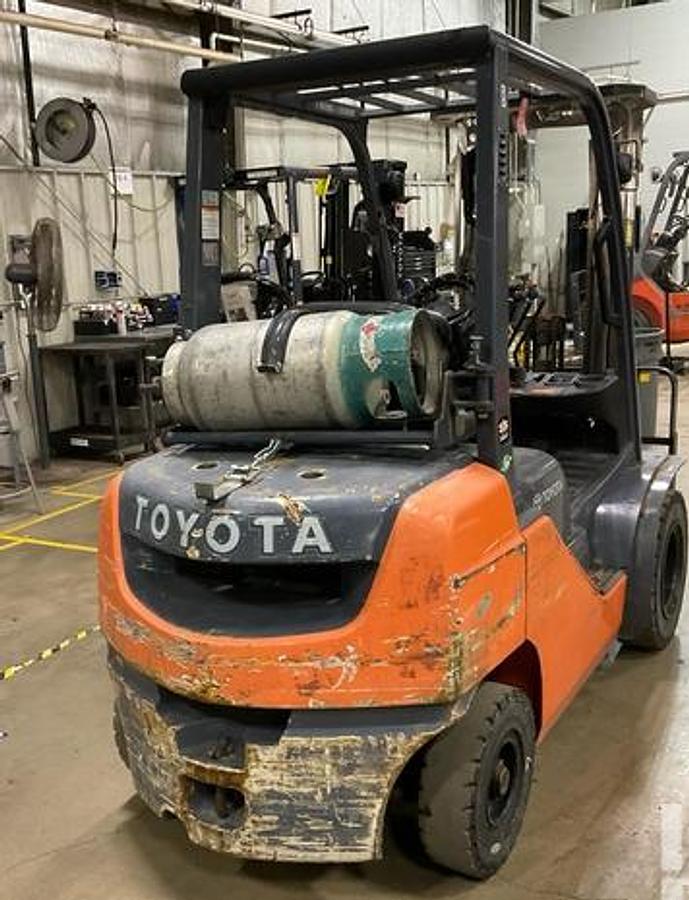 2019 Toyota 8FGU25 4,850 lb IC pneumatic forklift – rear view showing counterweight, LP tank mount, overhead guard, and solid pneumatic tires