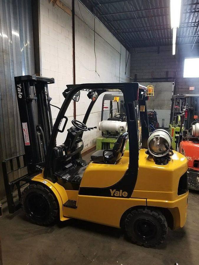Side profile of 2013 Yale GLP060VX LPG pneumatic forklift showing mast rails, chassis layout, and treaded tires during Brampton deployment