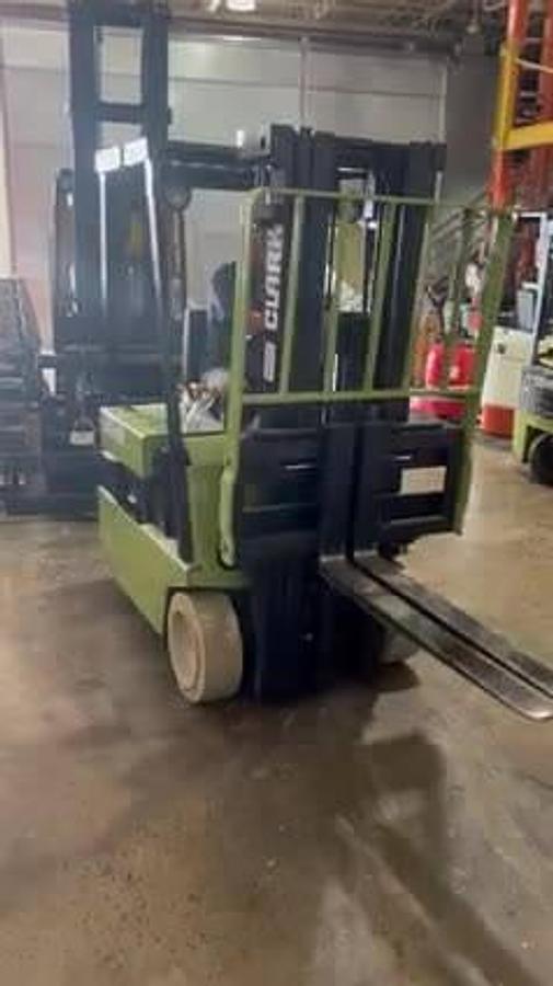 Front view of Clark TM15S electric sit-down forklift with forks raised showing triple-stage mast, extended 42” forks, load backrest, and CSA-certified chassis – unit