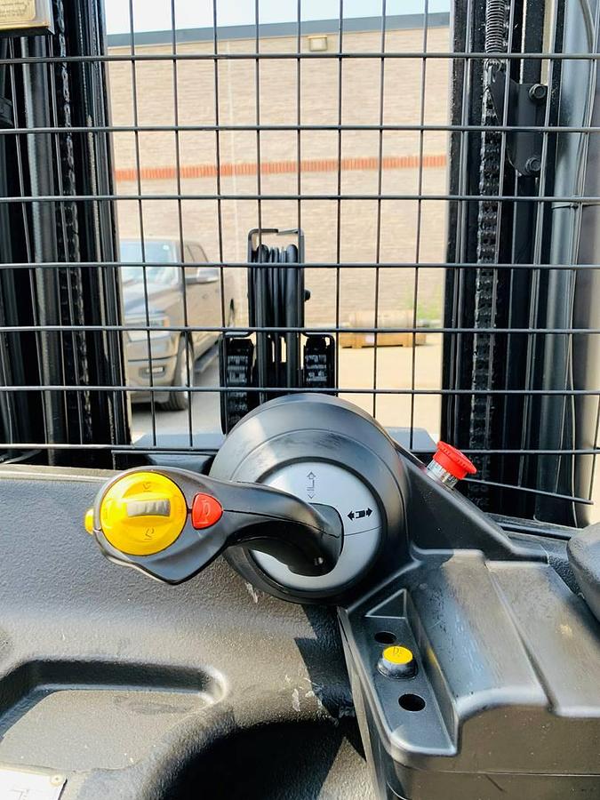 Operator compartment view of refurbished 2018 Yale NR045EB electric reach truck showing joystick control, steering wheel, and CSA inspection decal during Ontario deployment