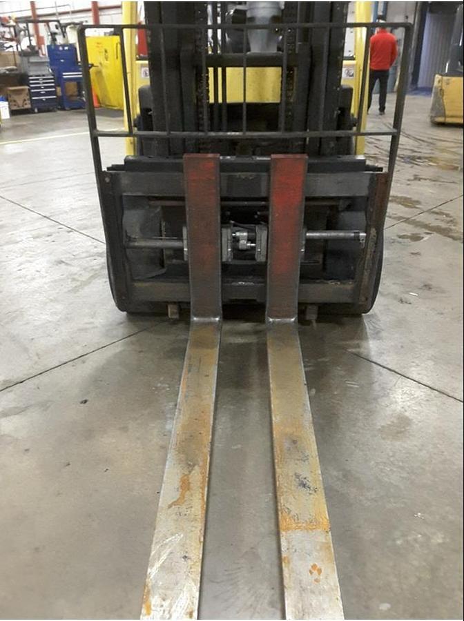 Close-up of 2-stage mast and 60" forks on Hyster S155FT diesel cushion forklift showing fork positioner and load backrest during Brampton deployment