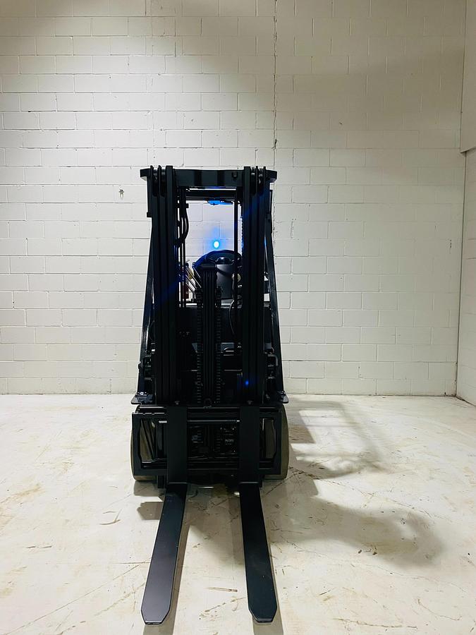 Front mast view of Toyota 8FBCU20 COM electric sit-down forklift showing triple-stage rails, tilt cylinders, and CSA-certified mast – unit staged in Brampton ON