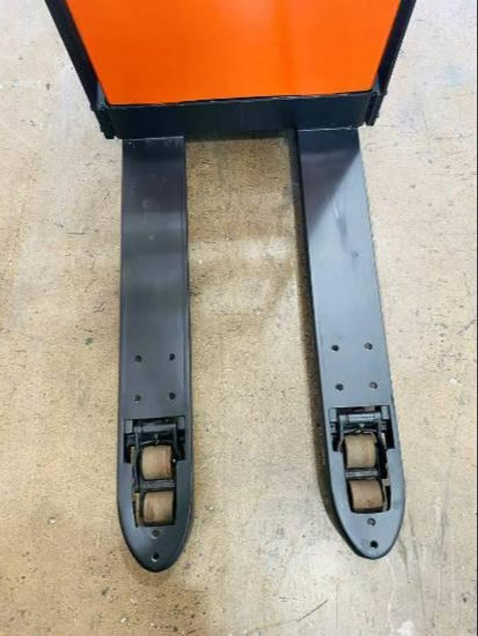 Downward view of refurbished 2016 BT LPE200/8 electric walkie/rider pallet jack showing 27" x 45" forks extending forward, flip‑down operator platform folded, load backrest visible, and CSA certification decal during Ontario deployment.