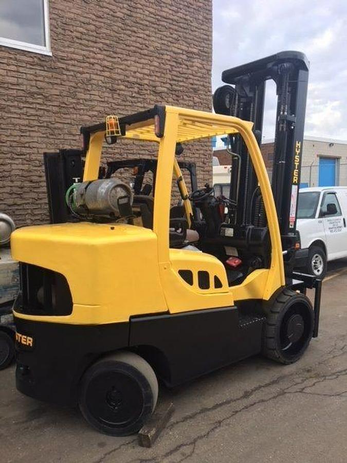 Rear view of refurbished 2014 Hyster S155FT LPG cushion forklift showing counterweight, rear tires, and propane tank bracket during Brampton deployment