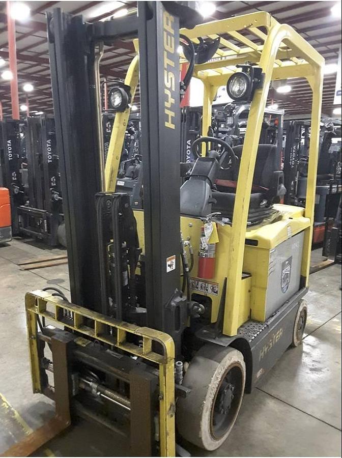 Front side view of refurbished 2013 Hyster E50XN electric forklift showing 2‑stage full free lift mast, 134" lift height, side shift, solid tires, and CSA certification decal during Ontario deployment.