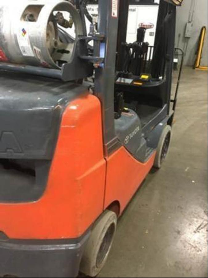 Opposite Rear view of refurbished 2014 Toyota 8FGCU25 LP gas forklift showing counterweight, propane tank mount, and CSA inspection tag during Brampton deployment