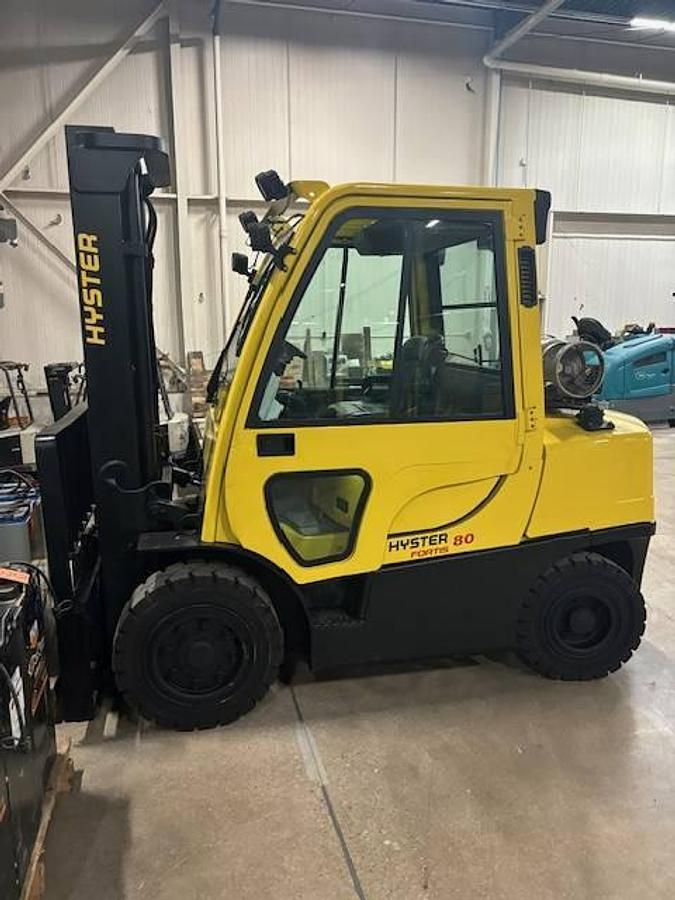Side view of refurbished 2011 Hyster H80FT LP Gas forklift showing full cab, solid pneumatic tires, and 2‑stage mast during Ontario deployment.