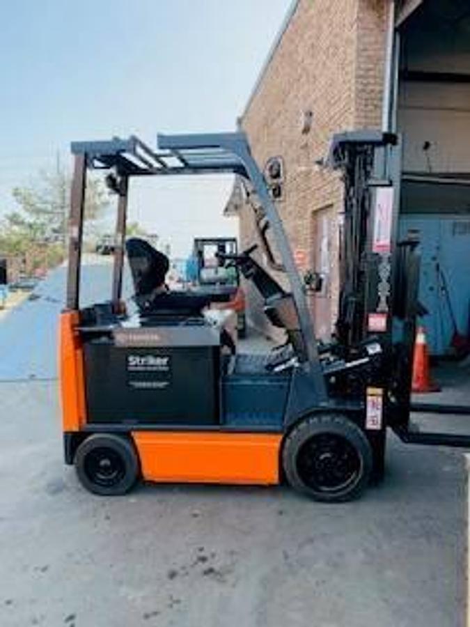 Opposite side view of 2020 Toyota 8FBCU30 electric forklift showing mast rails, CSA decals, and chassis profile during Brampton deployment