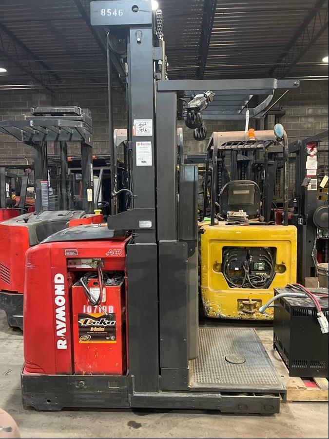 Side view of refurbished 2014 Raymond 560-OPC30TT electric order picker showing battery compartment, chassis frame, and platform base during Oakville deployment