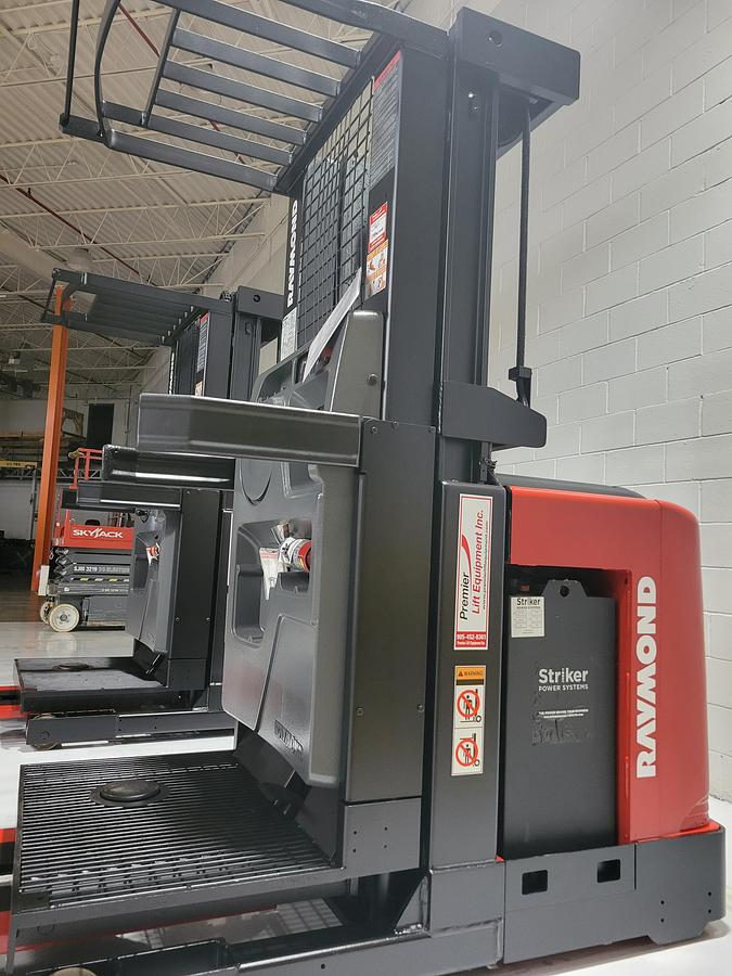 Opposite side view of refurbished 2006 Raymond 520-OPC30TT electric order picker showing battery enclosure, drive unit cover, and chassis structure during Mississauga deployment