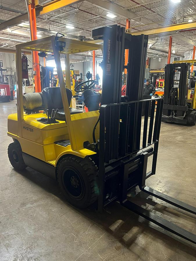 Front side angle view of Hyster H50XM propane pneumatic forklift – CSA-certified 5,000 lb chassis with 189” triple mast, 42” forks, and yard-rated pneumatic tires shown refurbished and sold chassis-only – safety-tagged in Brampton ON – Premier Lift Equipment