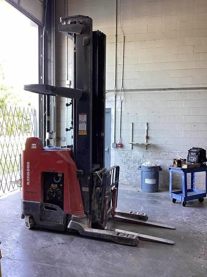 Opposite side profile of refurbished 2017 Raymond 750DR32TT electric deep-reach forklift showing 317" triple mast, reach carriage, and narrow aisle chassis during Brampton deployment