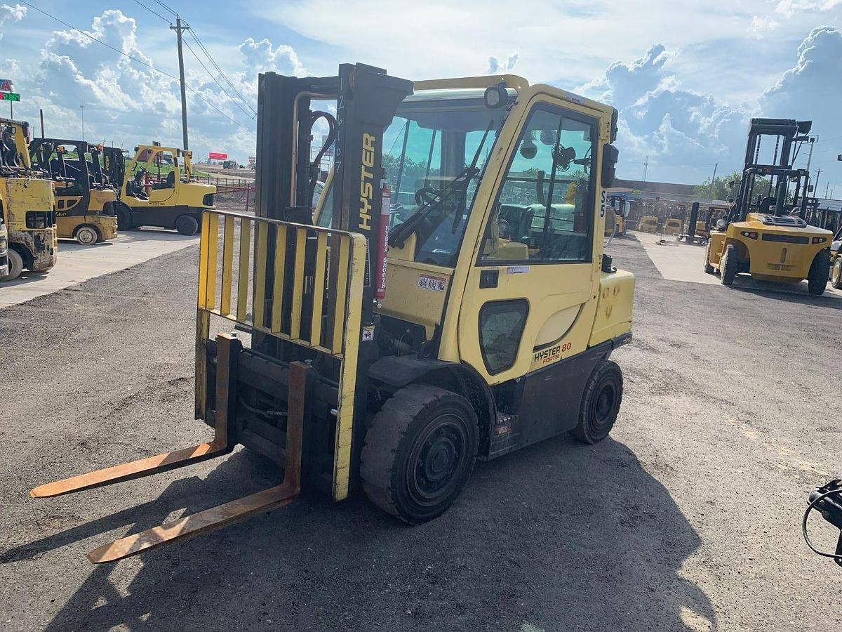 Opposite side view of refurbished 2015 Hyster H80FT LP Gas forklift showing counterweight, cab enclosure, and CSA certification decal during Ontario deployment.