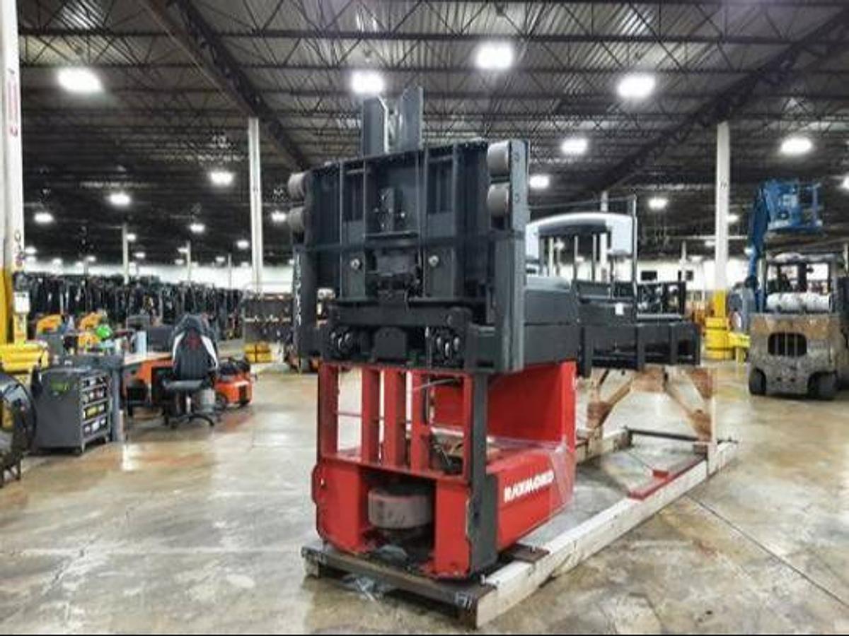 Undercarriage view of refurbished 2017 Raymond 560-OPC30TT electric order picker laid down and cradled, showing drive unit, caster wheel assembly, and chassis weldments during Concord deployment