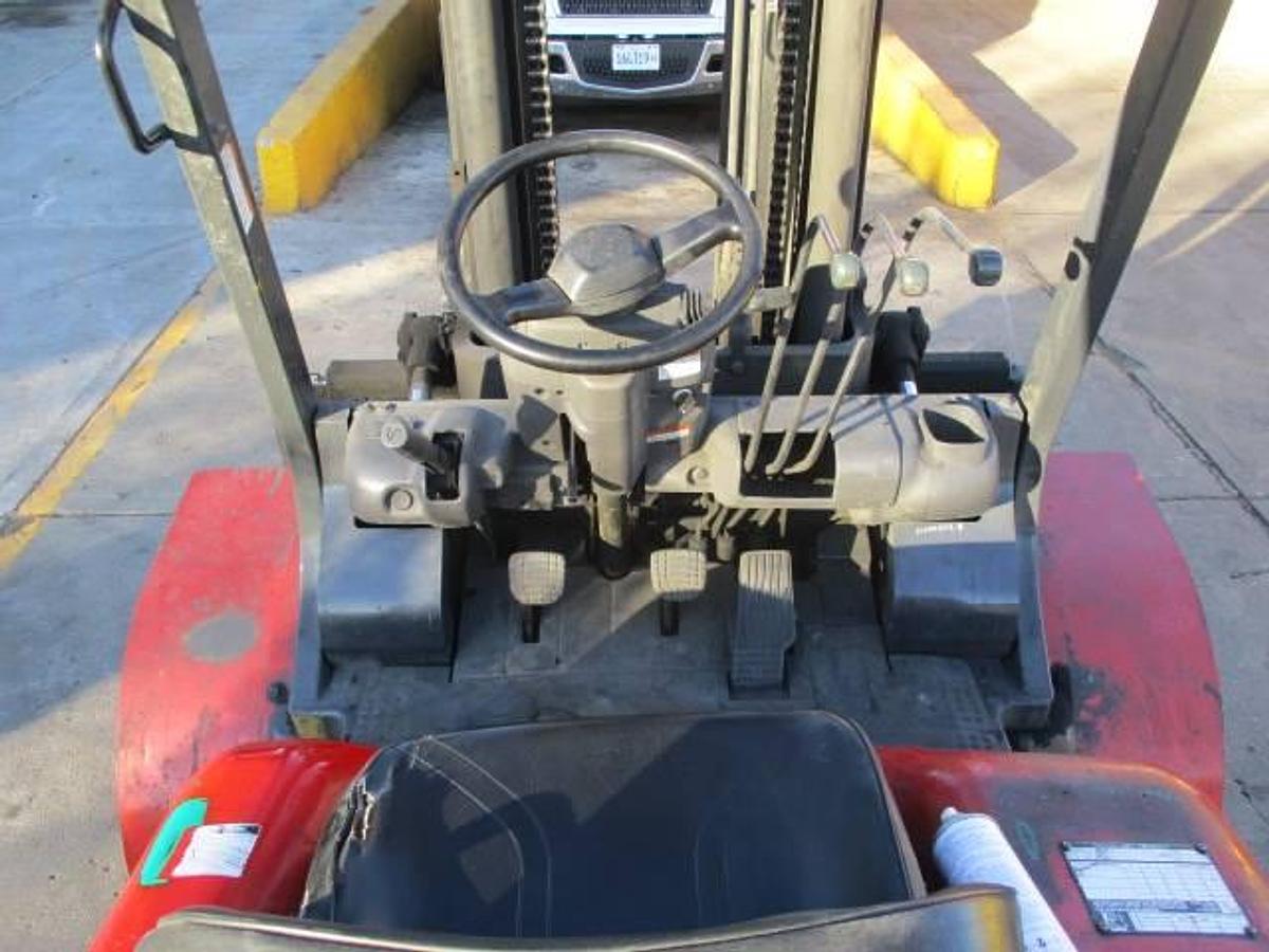 Operator controls of Tusk 1100PGA2‑8 propane forklift showing steering wheel, levers, and CSA compliance decal during Brampton deployment