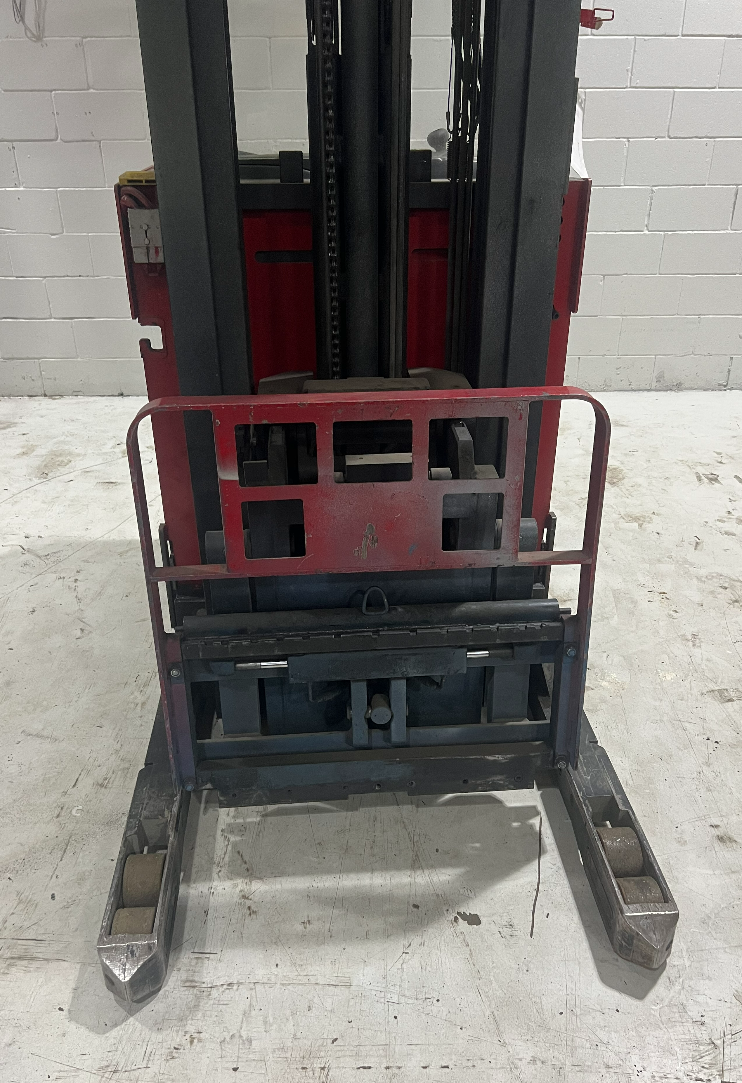 Close‑up view of Raymond EASI‑R45TT reach truck carriage showing load backrest, straddle legs, and integral sideshifter assembly.