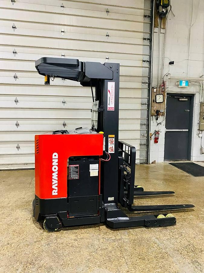 Side view of vintage 1996 Raymond EASIR40TT electric reach truck showing battery compartment, chassis frame, and short mast during Concord deployment