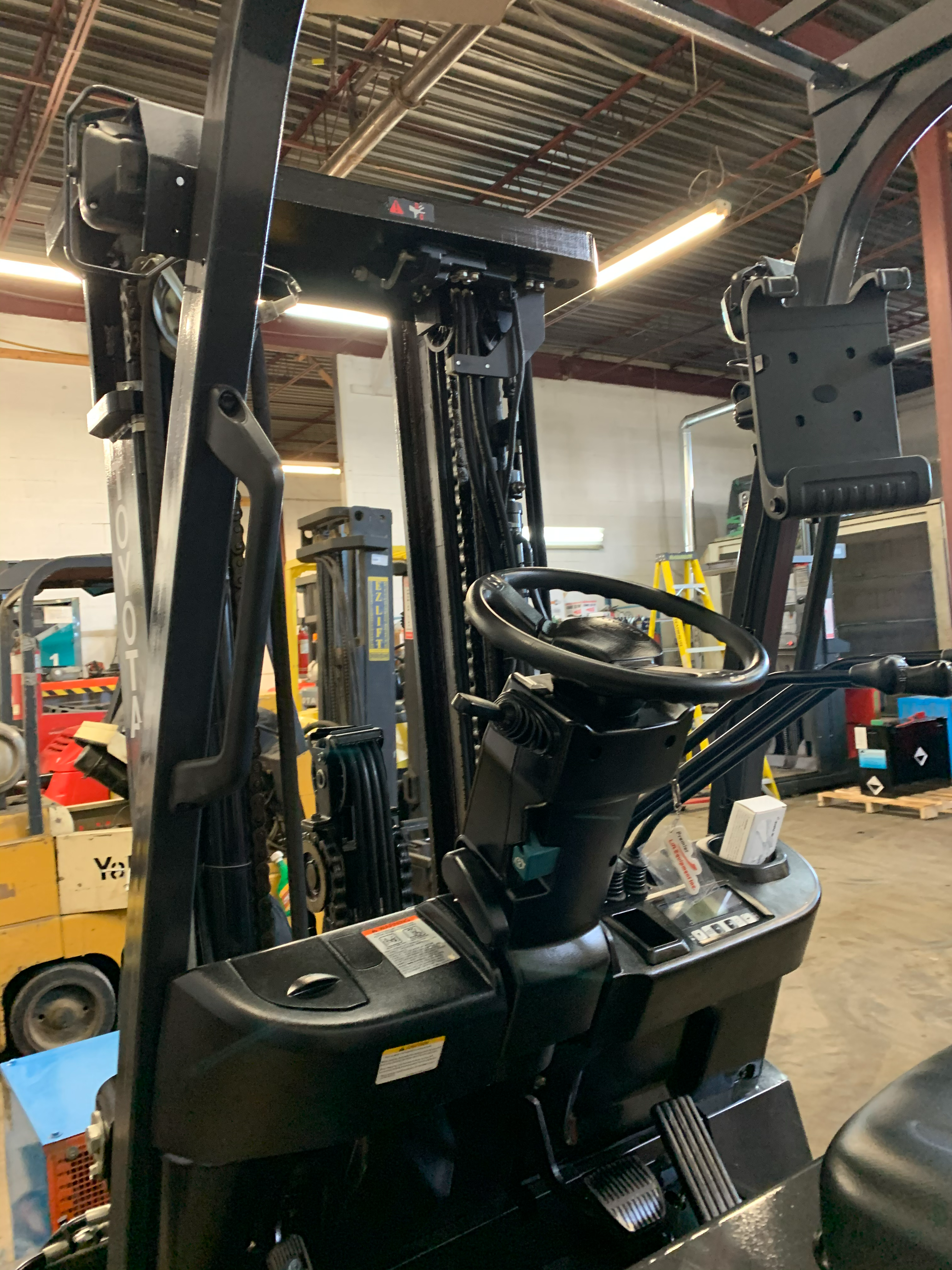 Toyota 8FBCU32 electric forklift — steering wheel and dash controls
