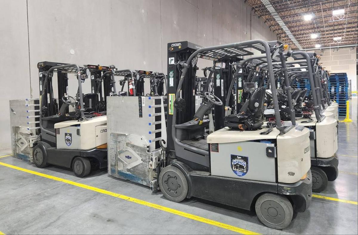 Side view of refurbished 2017 Crown FC5225‑50 electric forklift showing carton clamp 60" x 48, 4‑way hydraulics, and CSA certification decal during Ontario deployment.