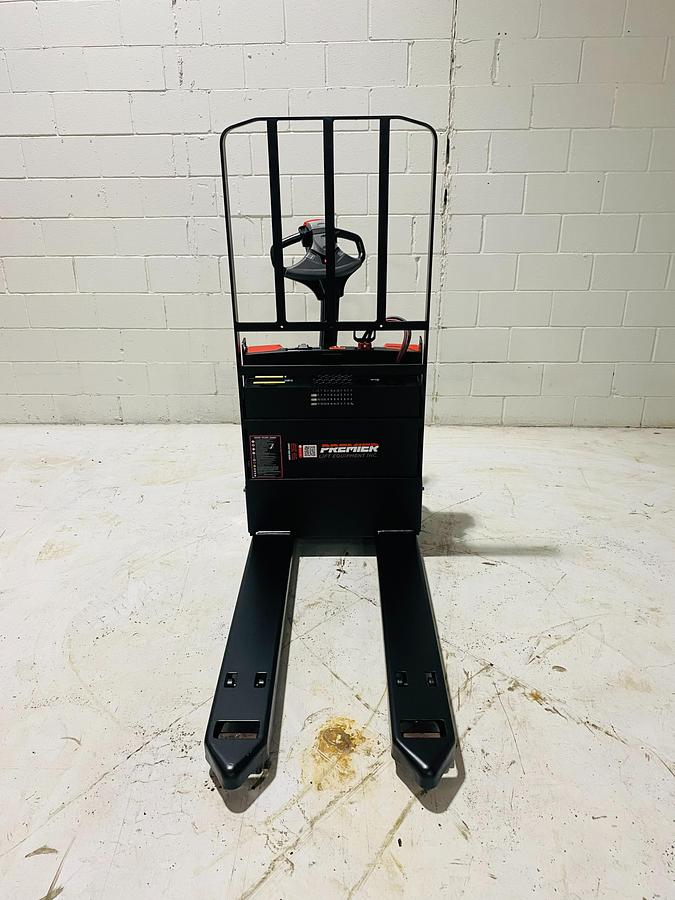 Front view facing 27” x 45” tapered forks on 2018 Raymond 8210 electric walkie pallet jack shown chassis only without battery or charger – CSA-certified 4,500 lb unit featuring reinforced fork tips, Class II carriage, and ergonomic tiller handle staged in Brampton ON; battery and charger available separately as extra options new or used – Premier Lift Equipment