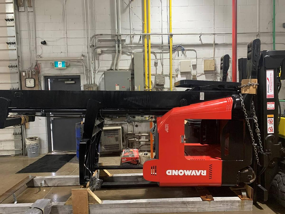 Side view of refurbished 2019 Raymond 772-R45TT electric reach truck laid down and cradled, showing chassis frame, mast rails, and reach mechanism with battery compartment excluded during Toronto deployment