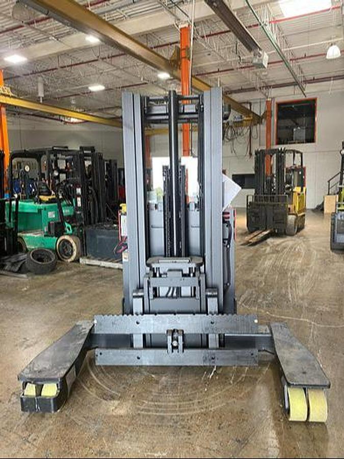 Front view of Raymond 4‑way reach electric forklift highlighting forks, mast assembly, and CSA certification decal
