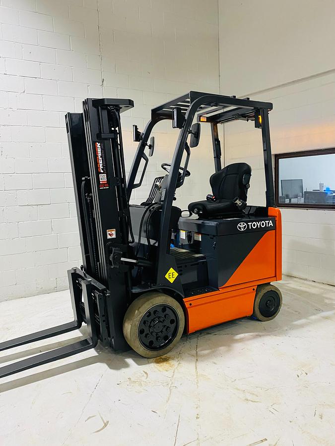 Angled side view of Toyota 8FBCU20 COM electric sit-down forklift showing forks, mast carriage, and CSA-certified frame – unit staged in Brampton ON