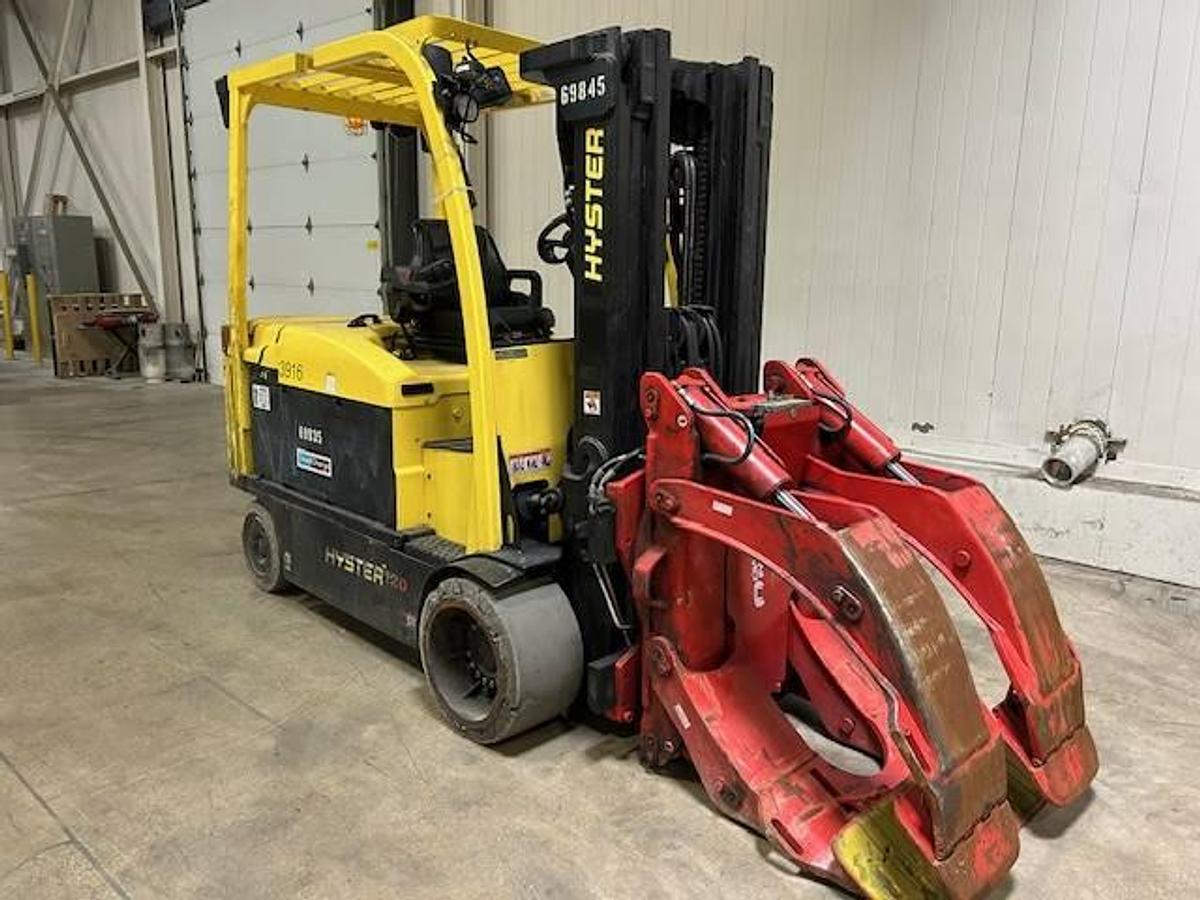 Front side view of refurbished 2019 Hyster E120XN electric forklift showing paper roll clamp with 10"–60" opening, 86"/169" mast, non‑marking tires, and CSA certification decal during Ontario deployment.