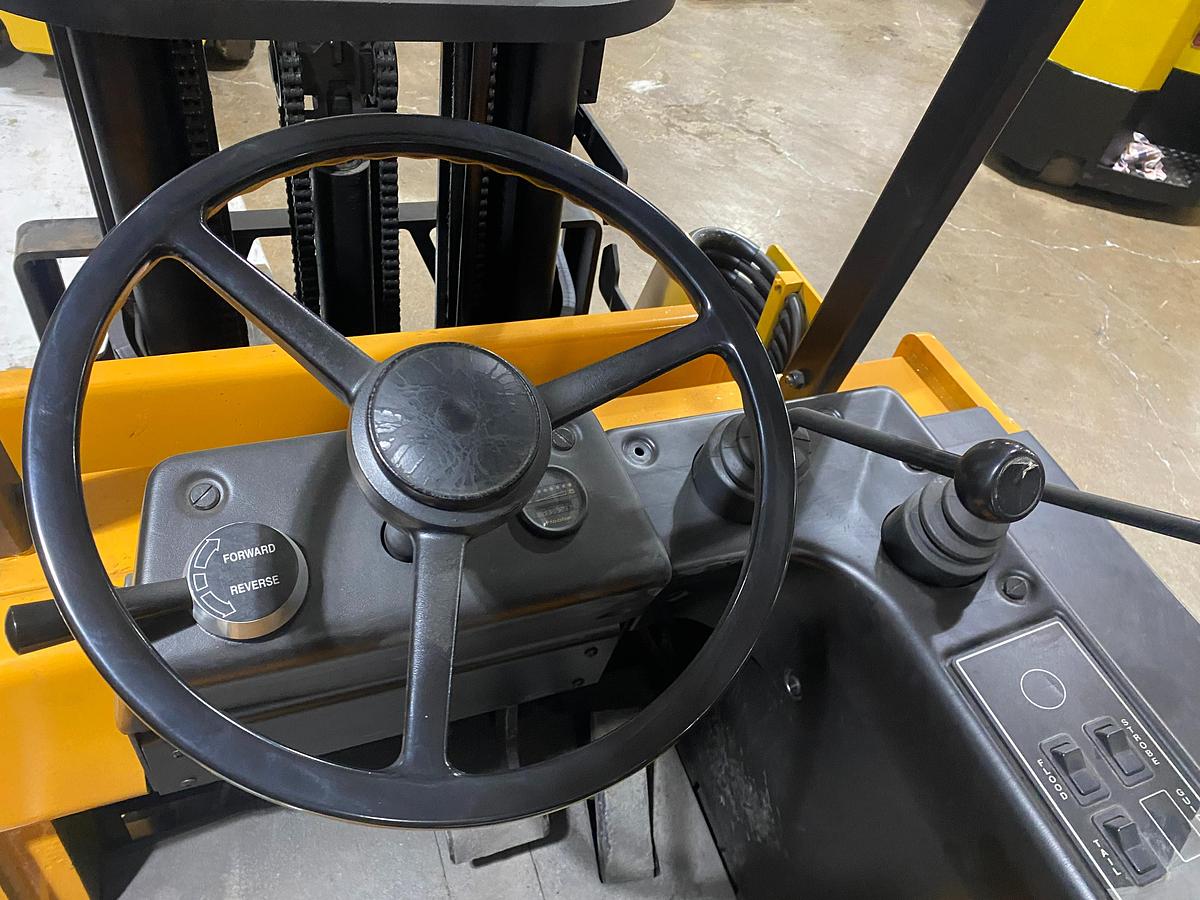 Operator steering wheel of Drexel SLT30 electric swing mast forklift showing side stance controls, dashboard, and CSA-certified interface – unit staged in Brampton ON