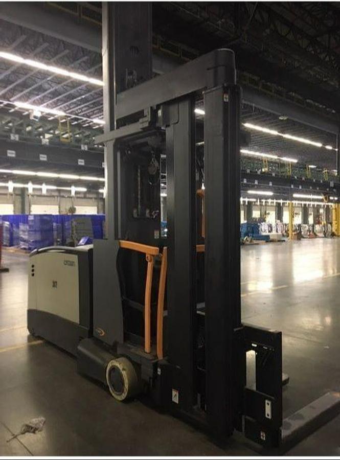 Front angled view of refurbished 2017 Crown TSP7000 electric turret truck showing turret mast, wire guidance system, 72 volt battery compartment, and CSA certification decal during Ontario deployment.