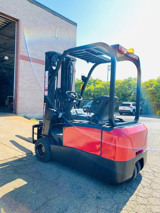 Rear side view of refurbished 2018 EP Equipment CPD20 3‑wheel electric forklift showing rear chassis, solid pneumatic tires, battery compartment, and CSA certification decal during Brampton deployment.