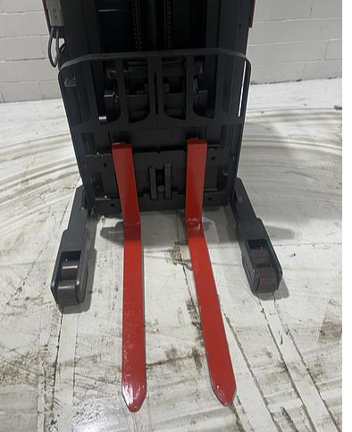 Close‑up of 42” forks and straddle legs on Raymond 31I‑R45TT single‑reach truck — Budget indoor electric unit.
