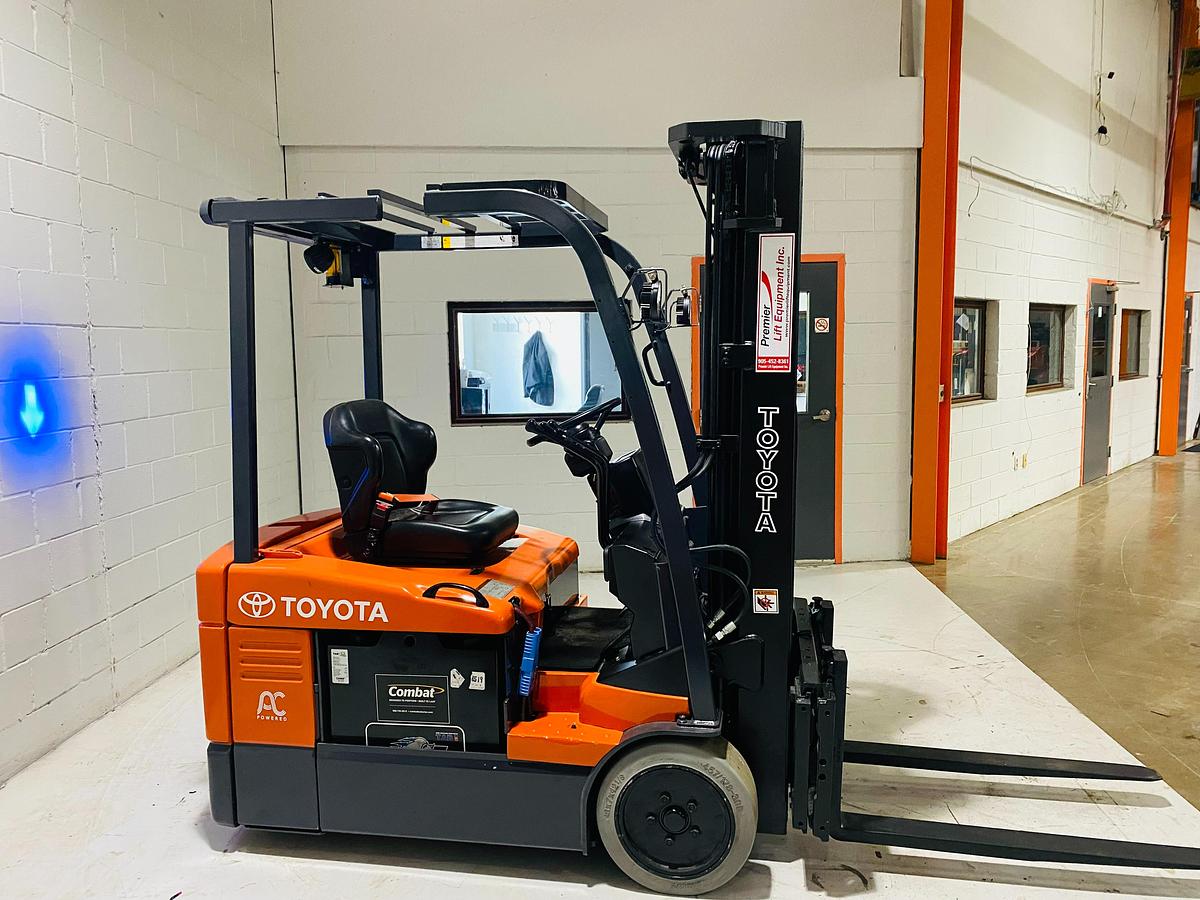 Profile view of 2012 Toyota 7FBEU15 electric forklift showing 3-wheel chassis, battery compartment, and side shift carriage