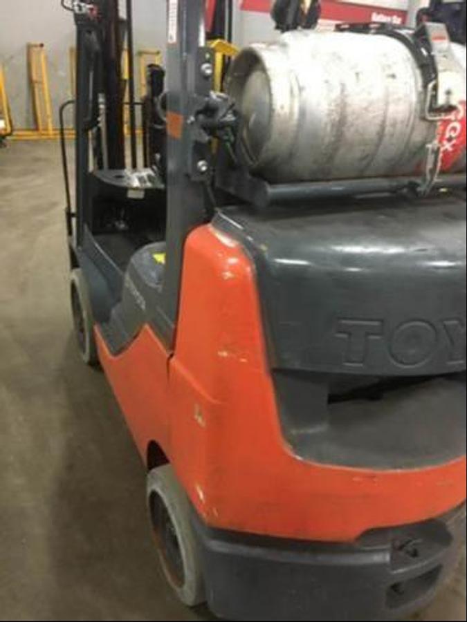 Rear view of refurbished 2014 Toyota 8FGCU25 LP gas forklift showing counterweight, propane tank mount, and CSA inspection tag during Brampton deployment