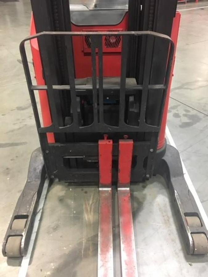 Close-up view of refurbished 2011 Raymond 740-R45TT EE-rated electric reach truck showing baselegs, 42" forks, side shift carriage, and load backrest during Concord deployment