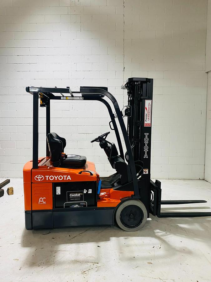 Opposite side view of 2015 Toyota 7FBEU15 three-wheel electric forklift showing mast tilt cylinders, side shift carriage, non-marking cushion tires, and CSA-certified chassis – unit staged in Brampton ON
