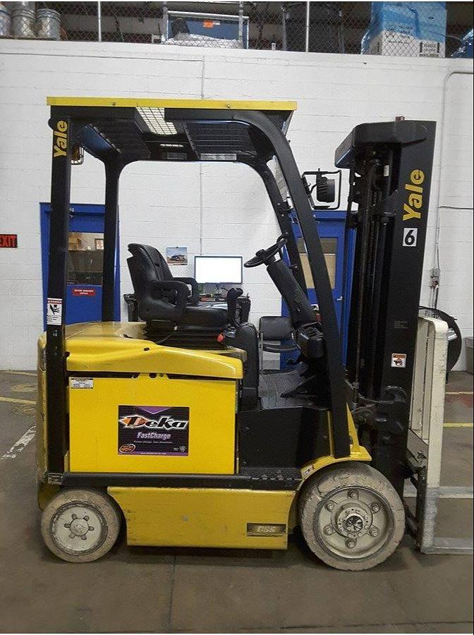 Opposite front side view of refurbished 2014 Yale ERC050VGN electric forklift showing mast, forks, operator cab, and cushion tire chassis during Brampton deployment